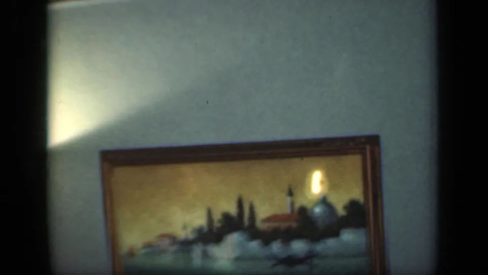 1949 New York interior detail with a framed coastal landscape painting beneath a warm glow on the wall.