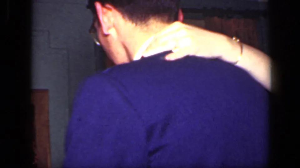 The camera catches the back of a suited dancer and a woman's arm around his shoulder in 1949 home-movie footage.