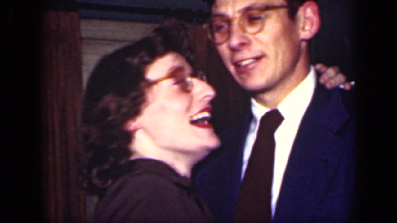 Smiling couple in formal clothes dancing close together indoors.