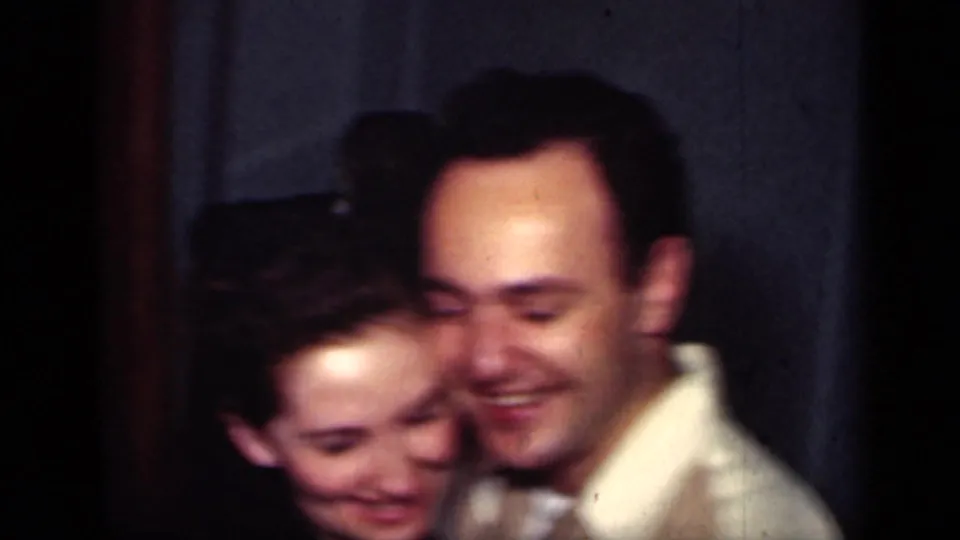 The couple embraces during a close dance, their faces softly blurred by motion in the 1949 New York home movie.