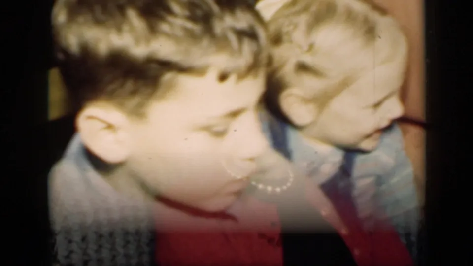 A brief 1949 New York home-movie glimpse shows two children close to the camera, with soft focus and motion blur.