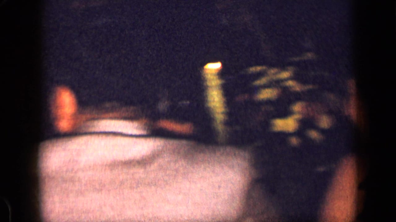 Adults seated around a dim table with candlelight and flowers in soft focus.
