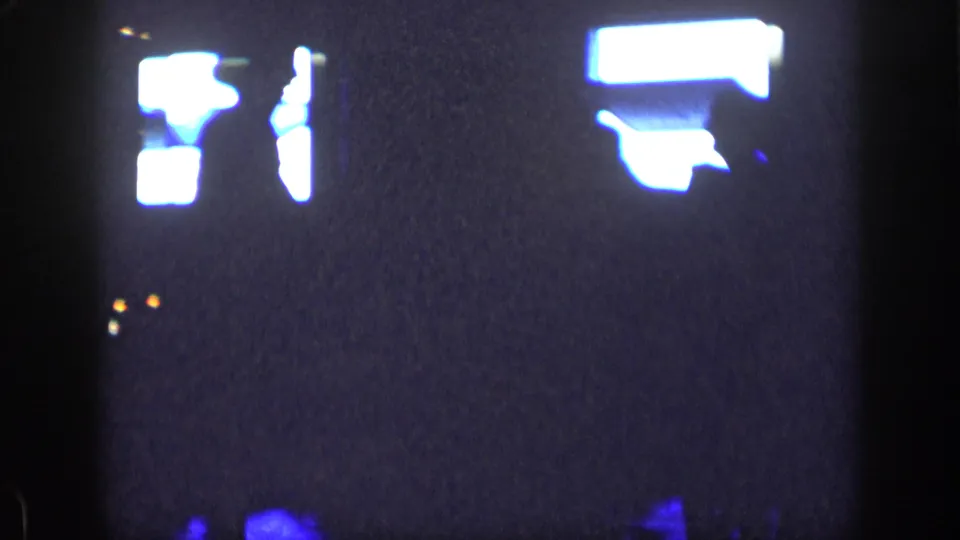 1957 New York home-movie frame with possible dancers reduced to bright and dark outlines in a dim room.