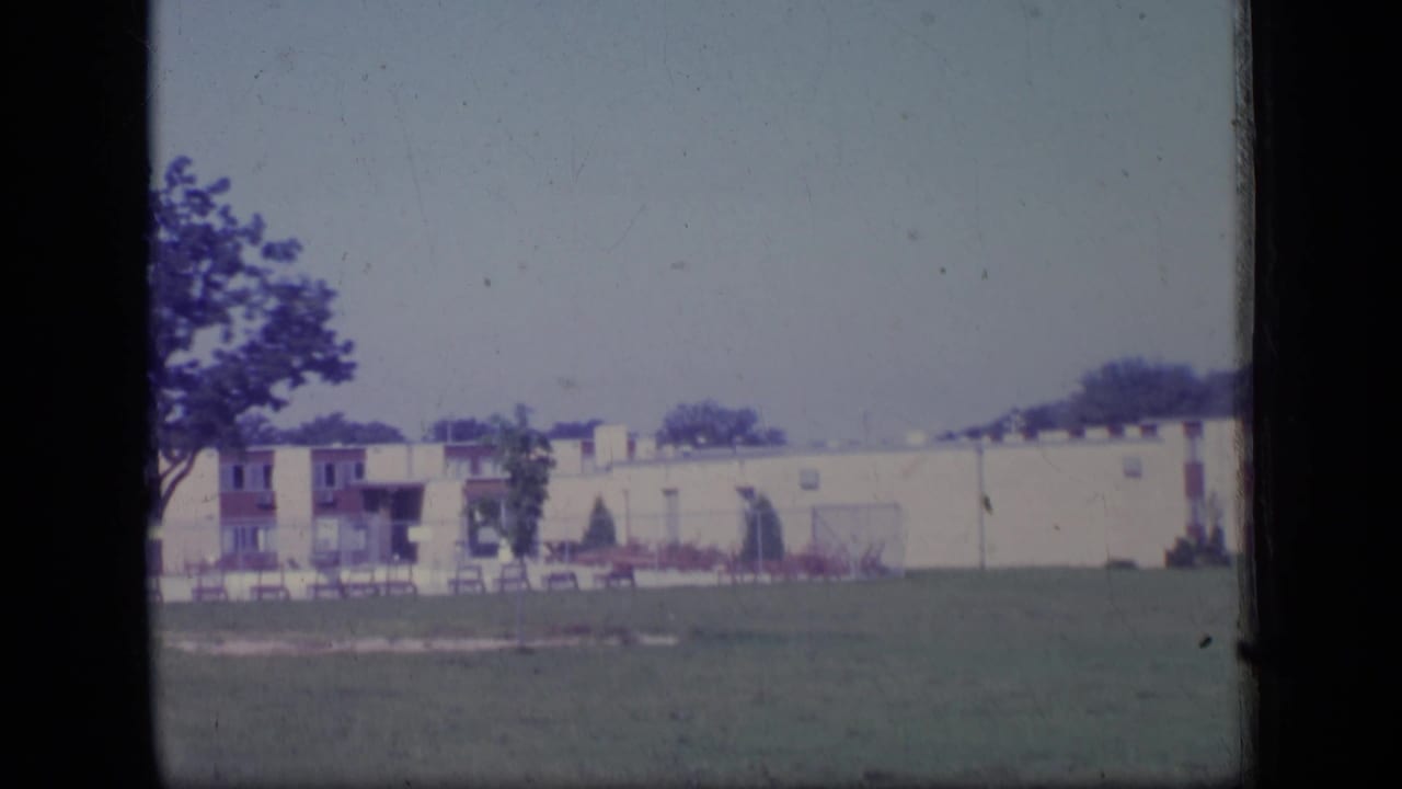 1970 New Jersey exterior view of low-rise apartments, a lawn, trees, and balconies in soft 8mm color.