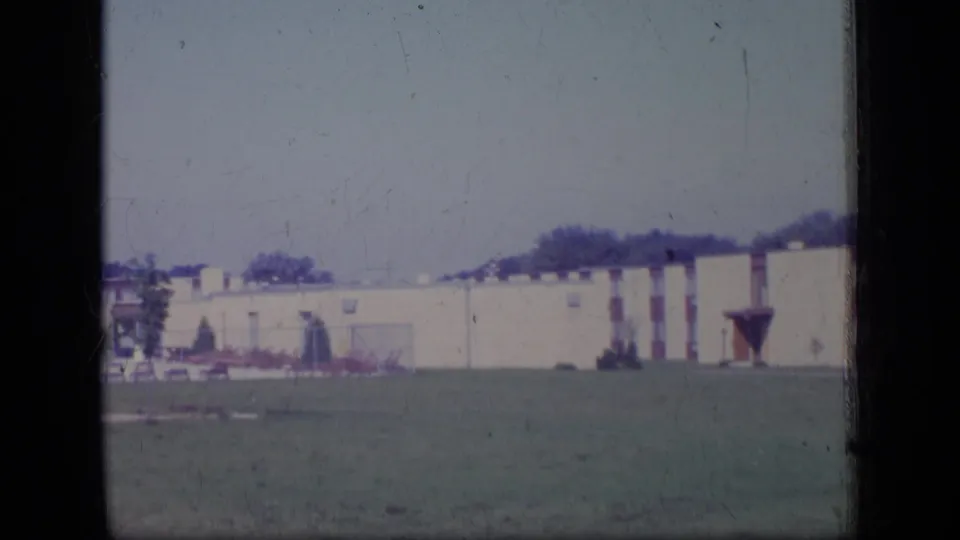 Final 1970 New Jersey 8mm view of the apartment complex exterior, lawn, trees, and soft faded sky.