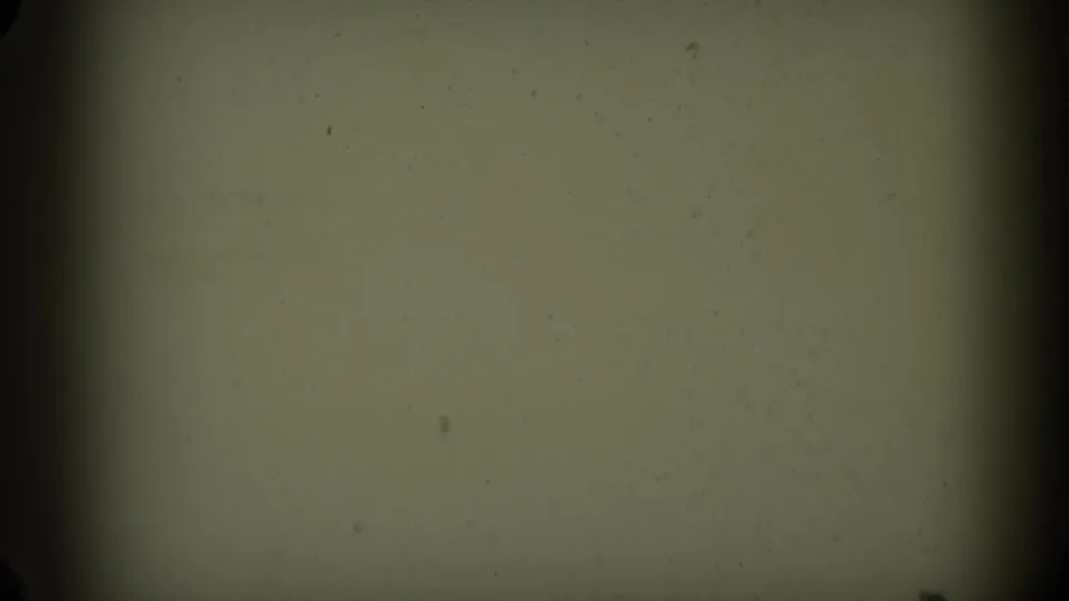 Green-tinted leader-like 8mm frame with soft vignetting, dark film edge, dust, and small surface marks.