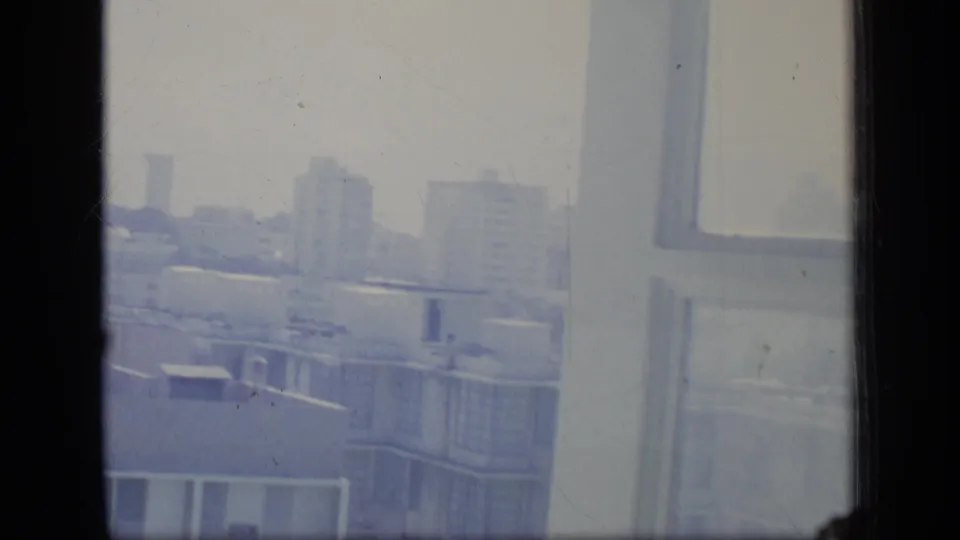 A final 1970 Puerto Rico frame shows distant towers, nearby concrete rooftops and a bright window edge in faded 8mm color.