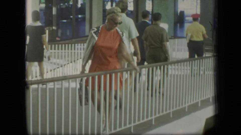The final frame shows the woman in orange near the railing in the covered Puerto Rico walkway, with multiple travelers walking ahead.