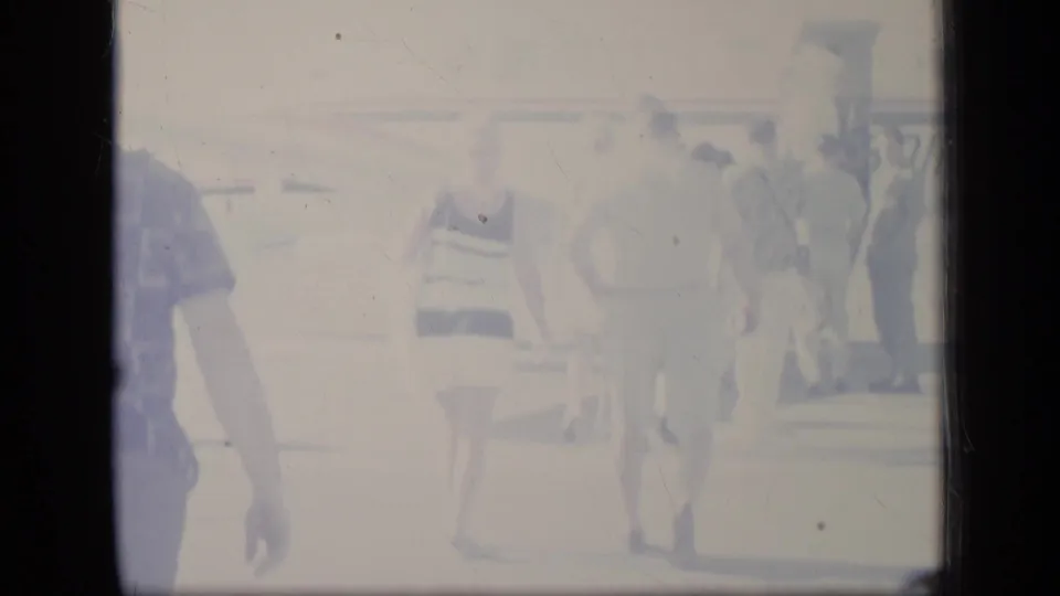 Overexposed 1970 Puerto Rico frame with passengers in vacation apparel approaching a small plane.