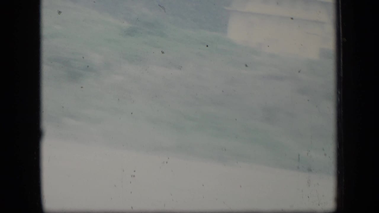 Soft 1970 Puerto Rico landscape view with pale sky, distant terrain, and visible 8mm frame borders.