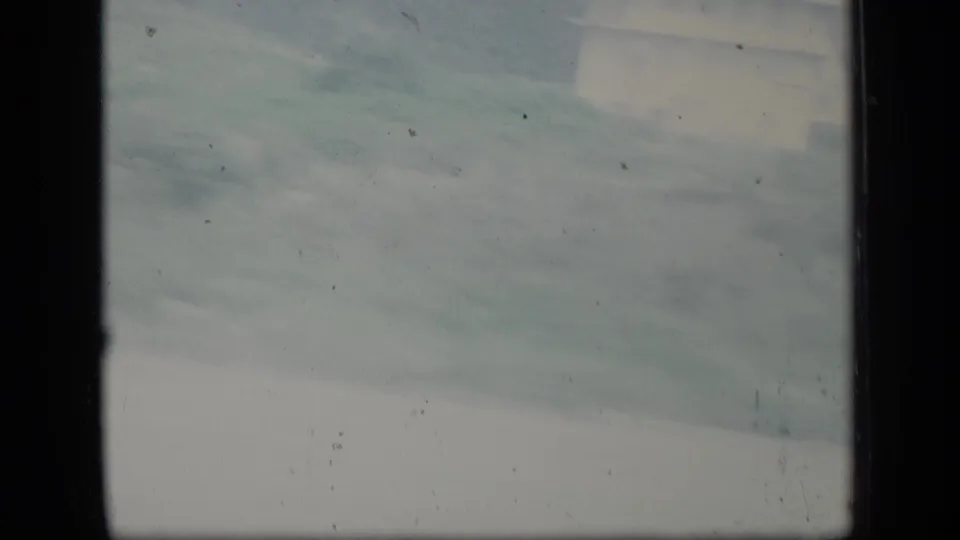 Soft 1970 Puerto Rico landscape view with pale sky, distant terrain, and visible 8mm frame borders.