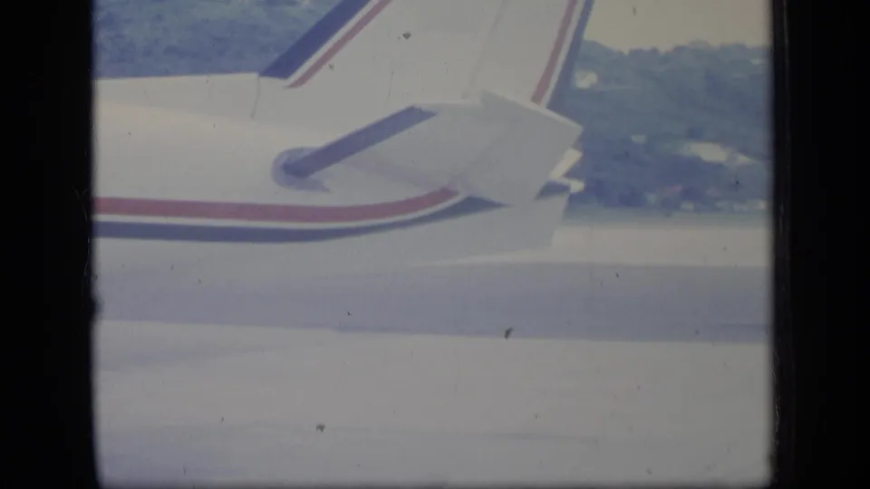 Tail section of the Air Indies aircraft on the Puerto Rico tarmac, with the fuselage stripe and rear stabilizer visible.