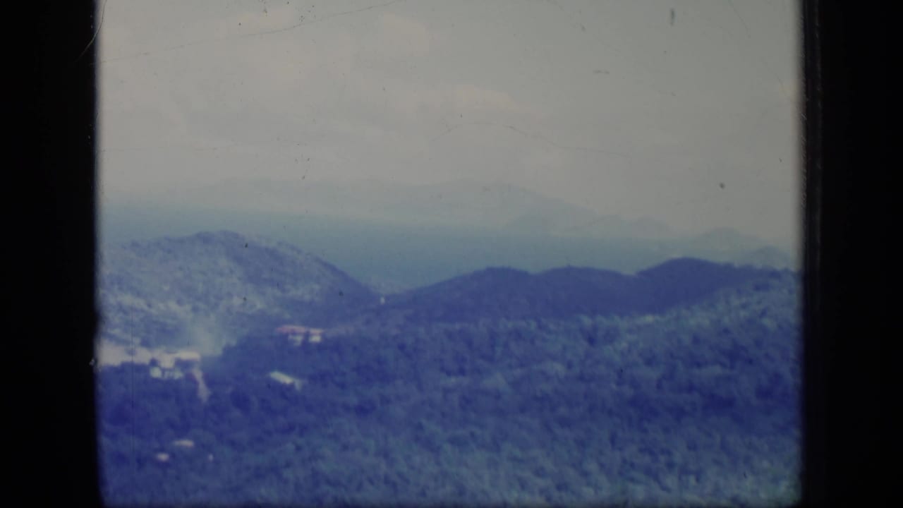 1970 Puerto Rico 8mm frame showing blue-green mountain slopes and a soft, misty horizon through the film gate.