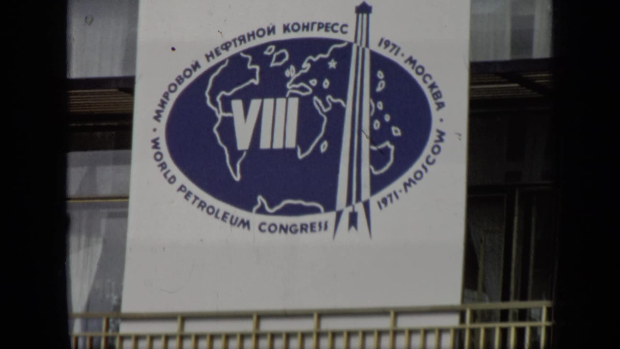 Large VIII World Petroleum Congress banner on a building, partly framed by dark vertical foreground shapes.
