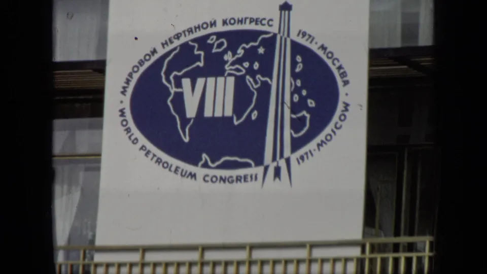 1971 Moscow 8mm frame showing a white VIII World Petroleum Congress banner with blue logo, Cyrillic and English text, and building windows behind it.