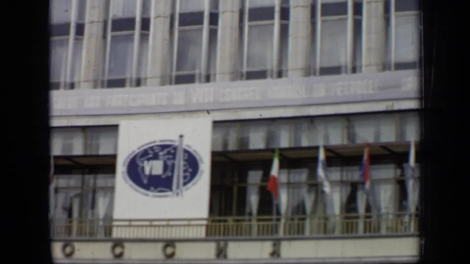1971 Moscow frame showing the congress banner on a government-style building facade, with flags below and dark window-like framing in front.