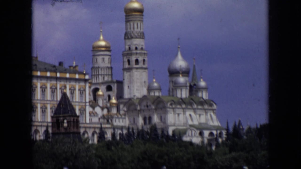 Kremlin domes and towers above trees under a blue sky.