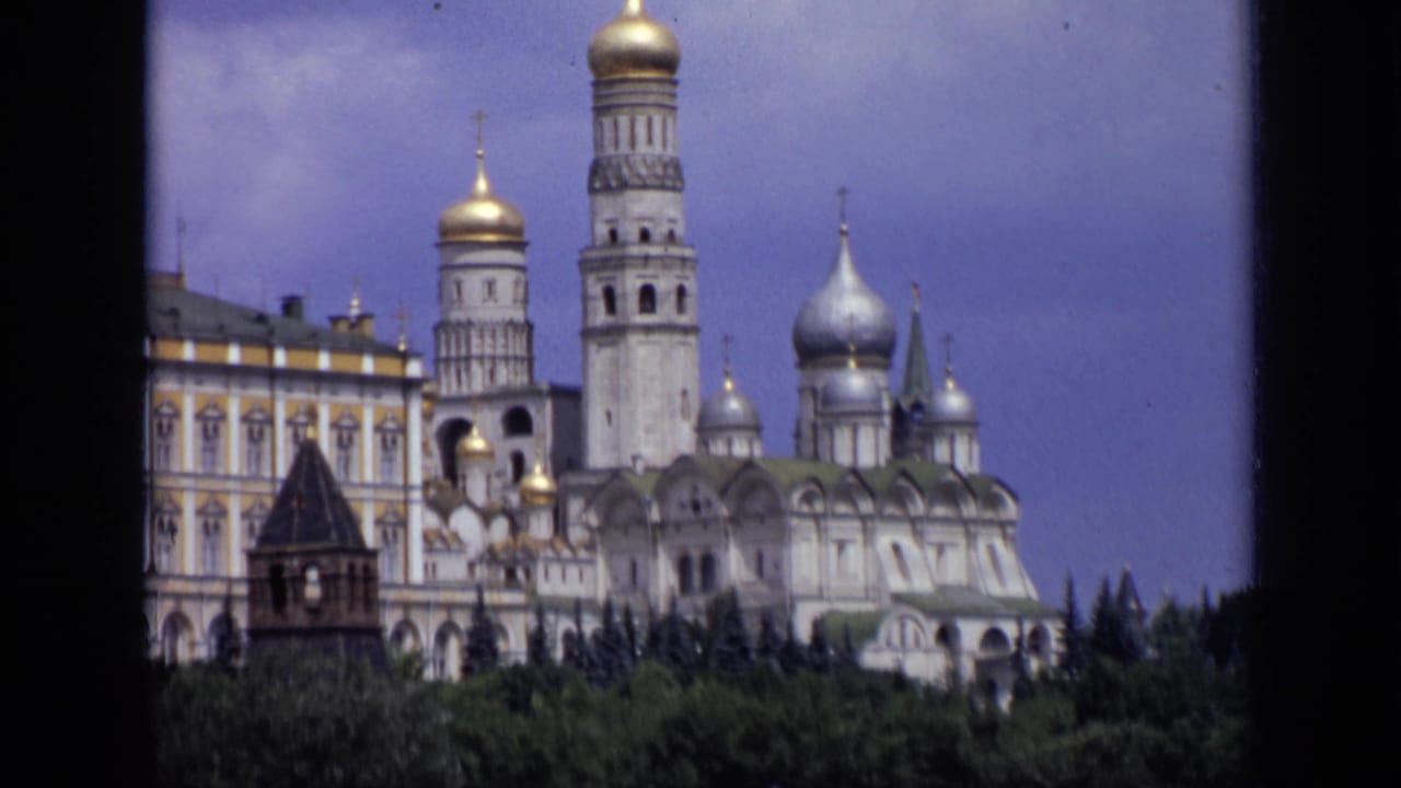 Moscow Kremlin architecture in 1971 home-movie footage, with gilded domes, a silver dome, bell tower, and treetops.