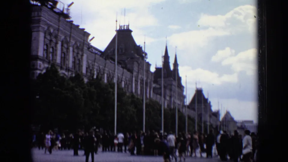 1971 Moscow frame looking down a busy plaza lined with trees, lamp posts, and historic building fronts.