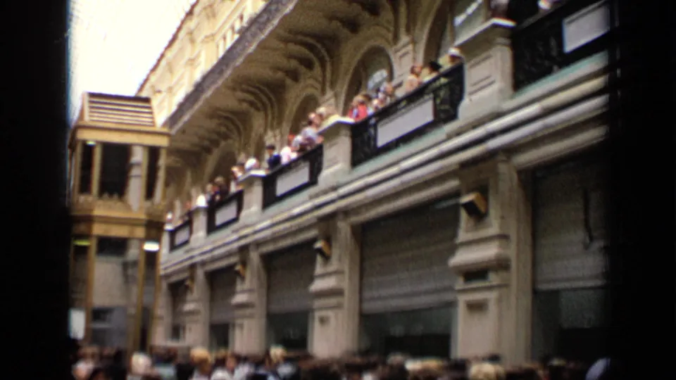 1971 Moscow frame showing the arcade’s upper balcony, gold-toned elevator shaft, closed storefront shutters, and crowded lower walkway.