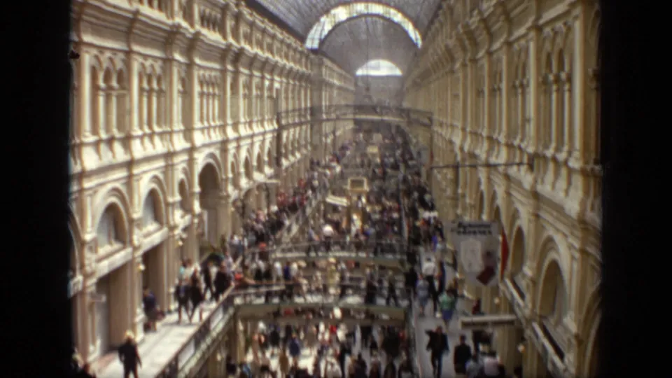 Elevated 1971 Moscow view across a busy shopping arcade, with ornate arches, upper walkways, and crowds below.