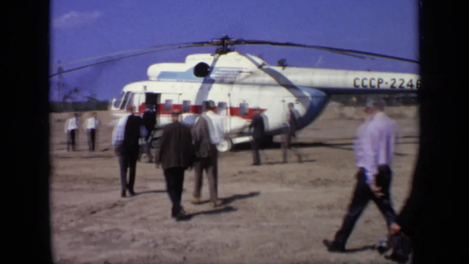 Men move alongside a white and red helicopter marked CCCP-22462 in the stated 1971 Moscow airfield scene.