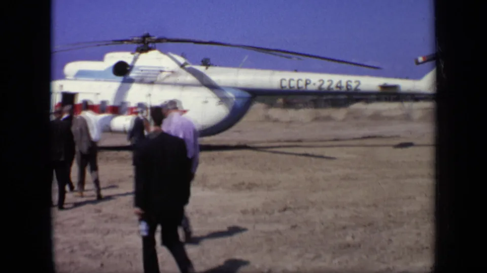 The helicopter’s CCCP-22462 registration is clear as men in suits and shirts gather near its side on the airfield.