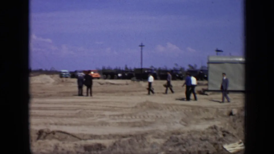 A wider 1971 Moscow view shows men crossing a dirt construction site beside a building edge, with parked vehicles beyond.