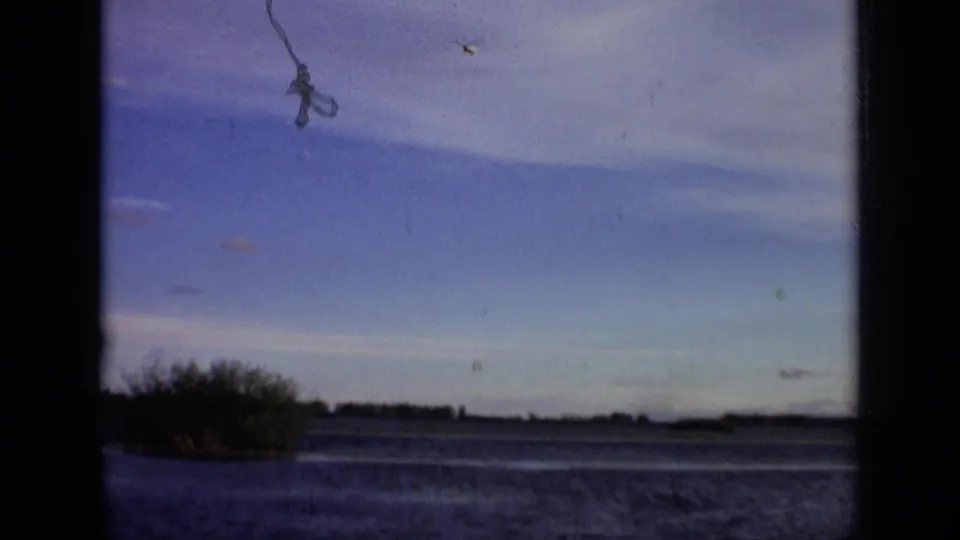 A broad lake and low wooded shoreline appear in 1971 8mm footage attributed to the Moscow, Russia area.