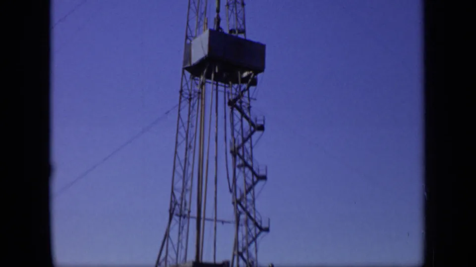 1971 Moscow 8mm frame focusing on the upper metal framework and suspended rig platform against open sky.
