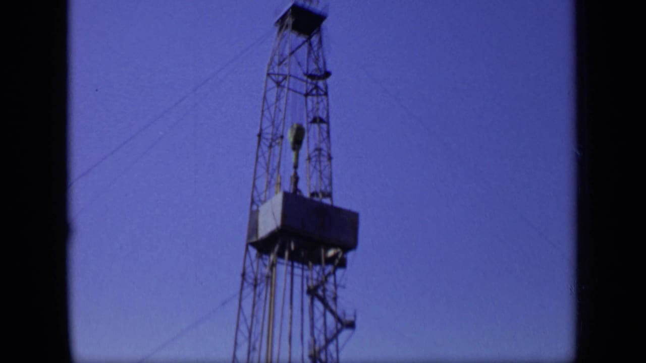 A 1971 Moscow industrial frame shows the upper structure of an oil rig, including its platform, cables, and tower bracing.