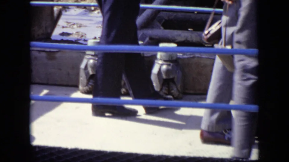 1971 Moscow frame showing adults walking near blue railings, large pipes, and industrial equipment during a site inspection.