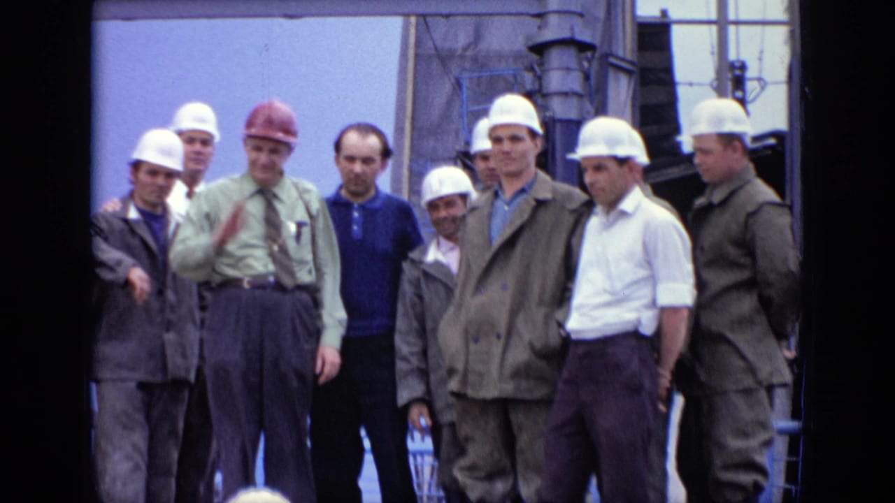 Group of workers in hard hats standing on an industrial platform.