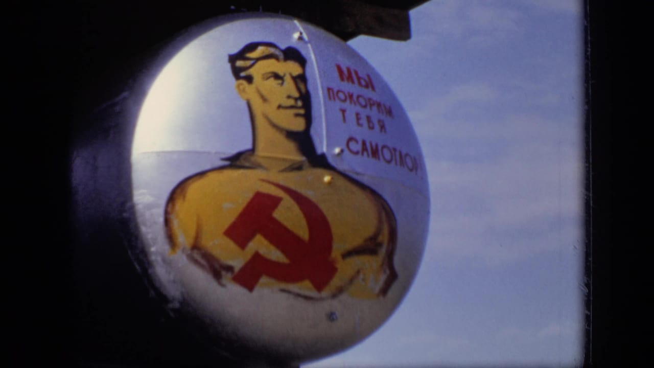 Painted communist sign with a worker figure and hammer-and-sickle emblem.