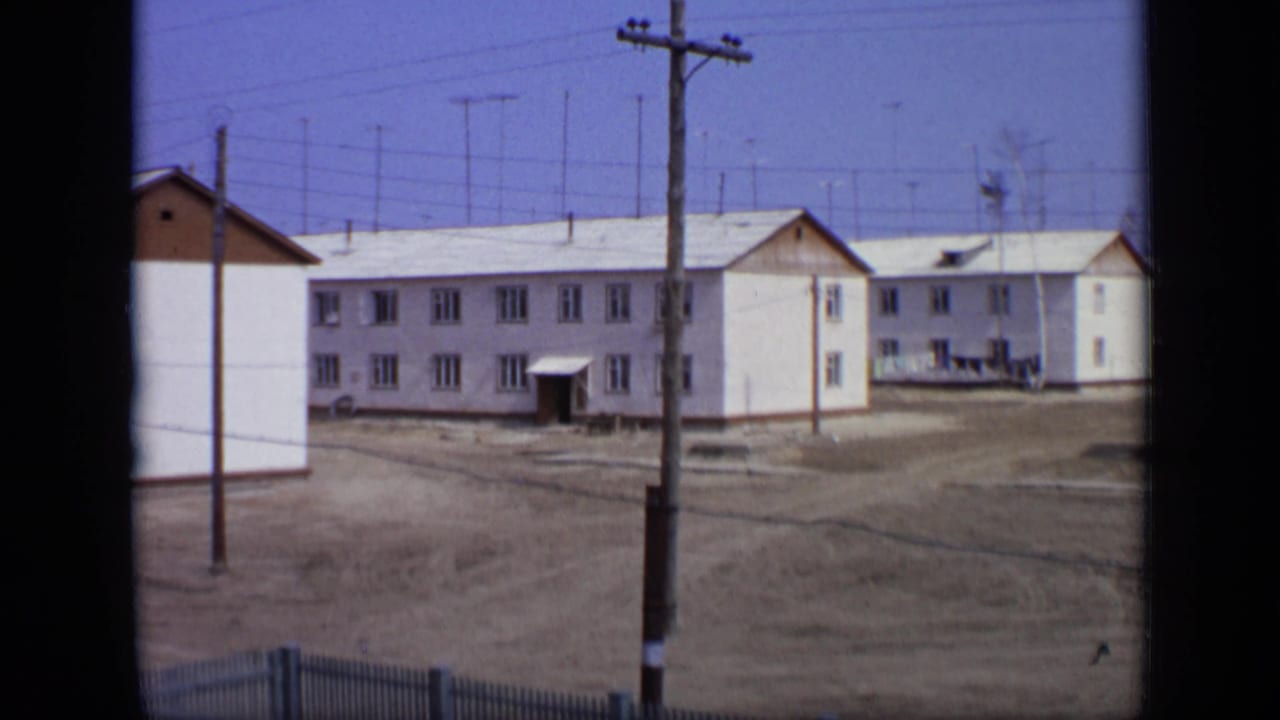 1971 Moscow residential buildings seen across bare ground, with wooden utility poles and overhead wires crossing the frame.