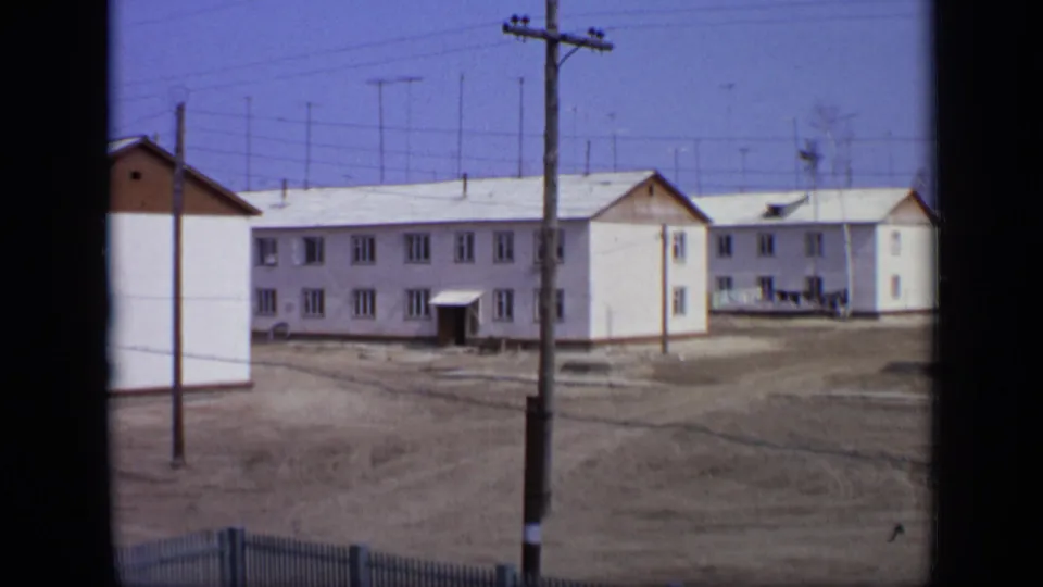 1971 Moscow residential buildings seen across bare ground, with wooden utility poles and overhead wires crossing the frame.
