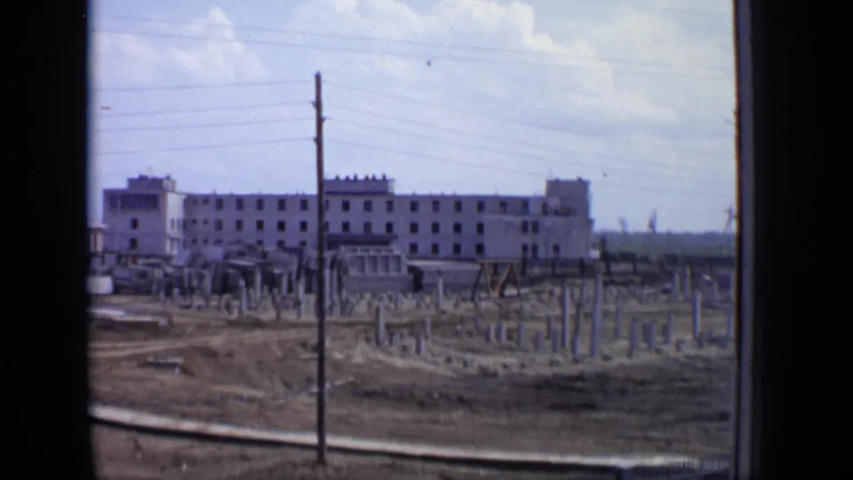 1971 Moscow construction area with exposed concrete foundation rows, a utility pole, and a large residential block in the background.