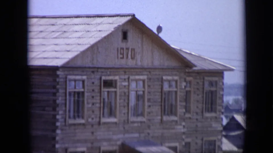 Wooden residential building in Moscow with 1970 visible on the gable and tall windows below.