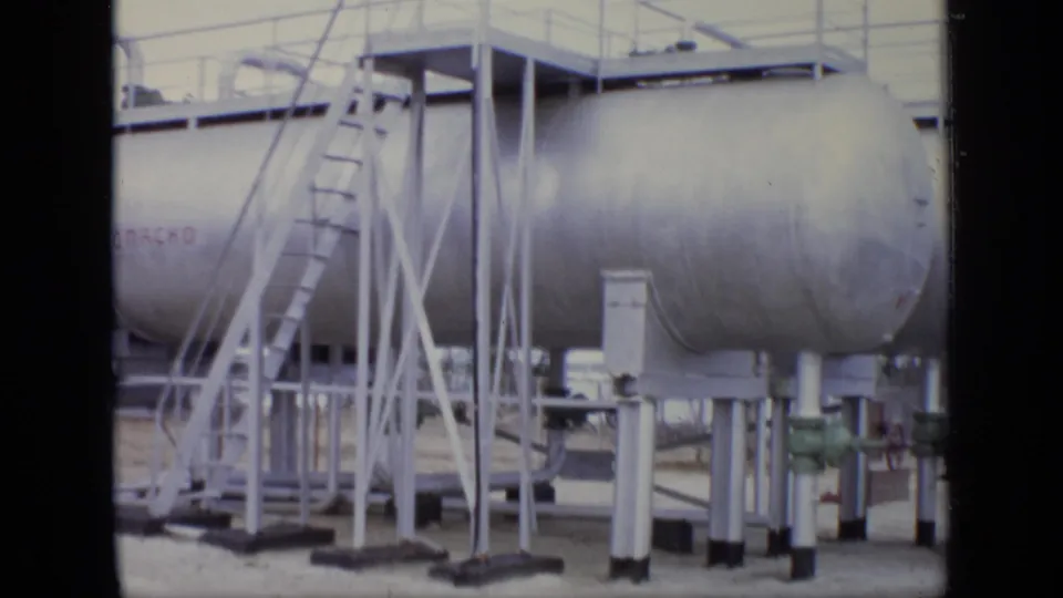 Close view of silver storage tanks in the 1971 Moscow industrial site, including ladders, supports, railings, and faint tank lettering.
