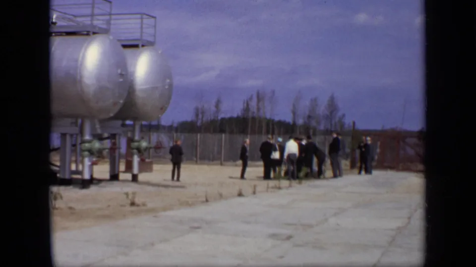 A wider 1971 Moscow view shows adult visitors near large industrial tanks, paved ground, fencing, and bare trees.