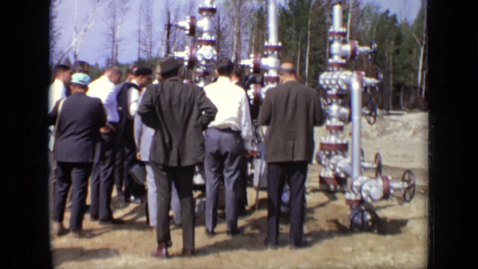 A final 1971 Moscow frame shows the group still gathered around vertical pipework and valve wheels in the outdoor field setting.
