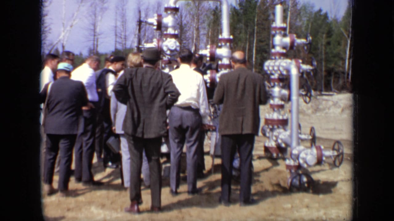 1971 Moscow footage shows men in suits and hats clustered near large metal valve equipment outdoors.