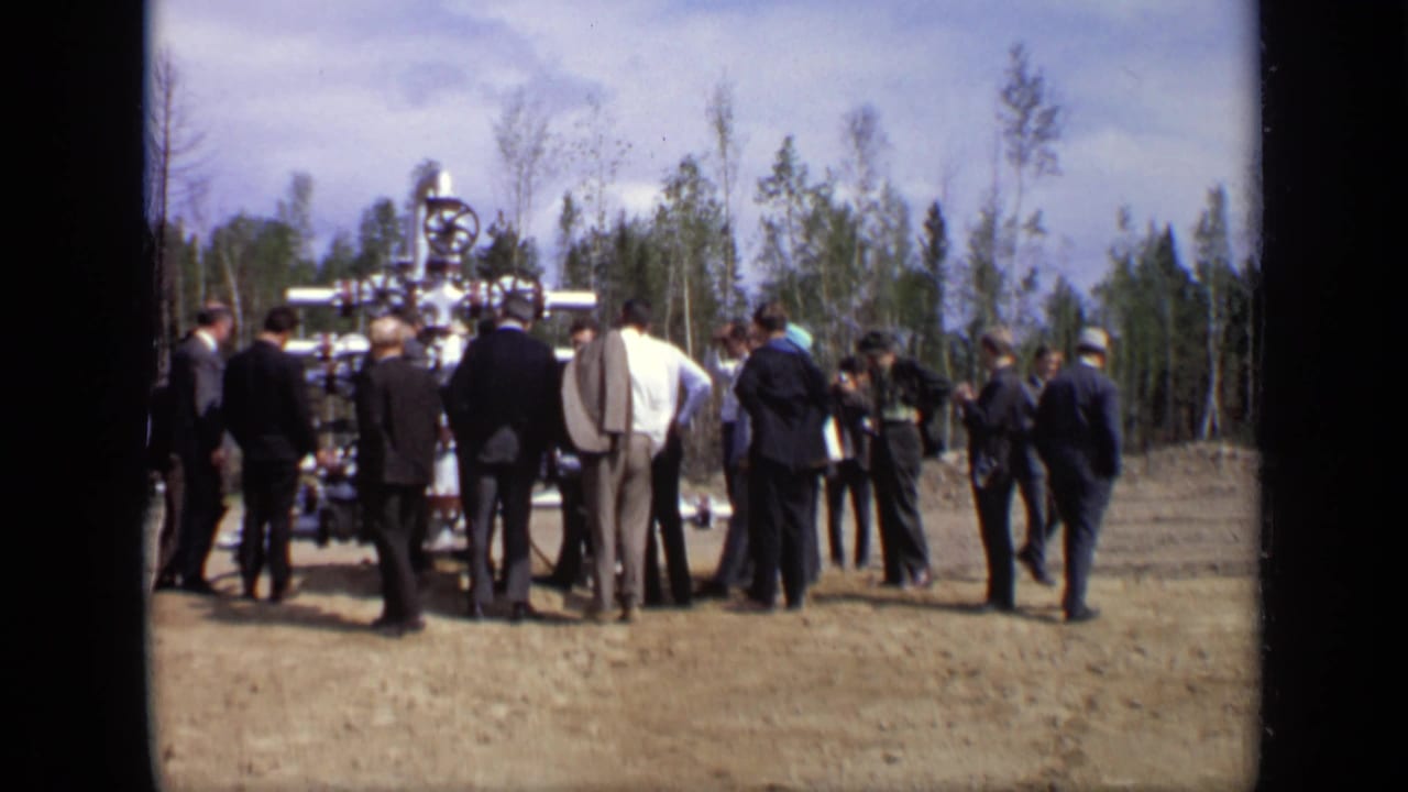 Men gather in a wooded Moscow clearing around exposed industrial valve equipment during a 1971 inspection scene.