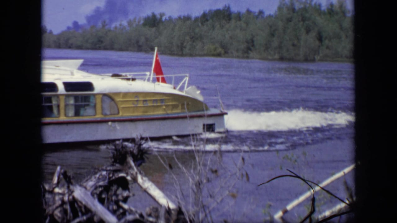 Motorboat continues along the river with a white wake behind it.