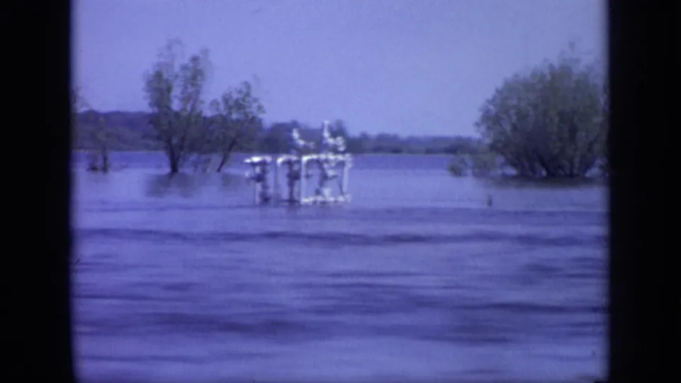 1971 8mm Moscow frame showing a closer white boat or small platform near trees standing in calm floodwater.