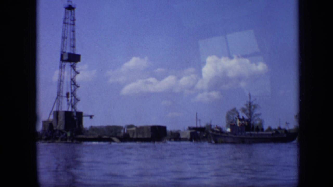 1971 Moscow waterfront view with a tall crane barge, small boat, rippling water, and scattered clouds in an 8mm frame.