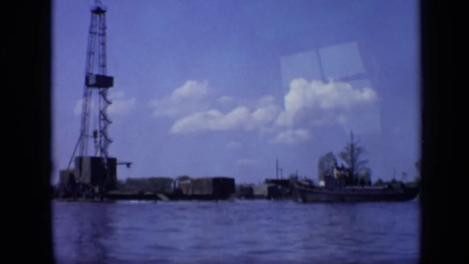 1971 Moscow waterfront view with a tall crane barge, small boat, rippling water, and scattered clouds in an 8mm frame.