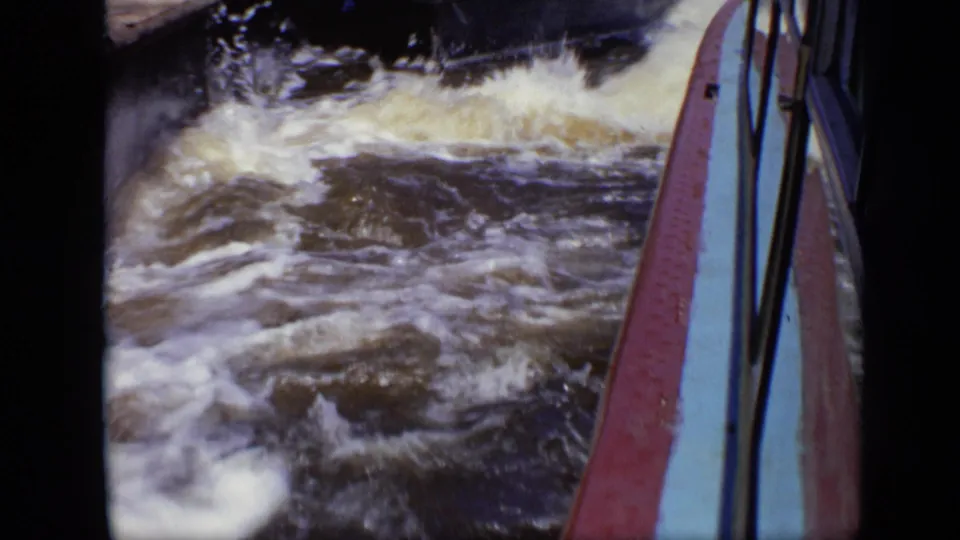 1971 Moscow 8mm frame showing turbulent water next to a boat rail, with soft focus and dark frame edges.