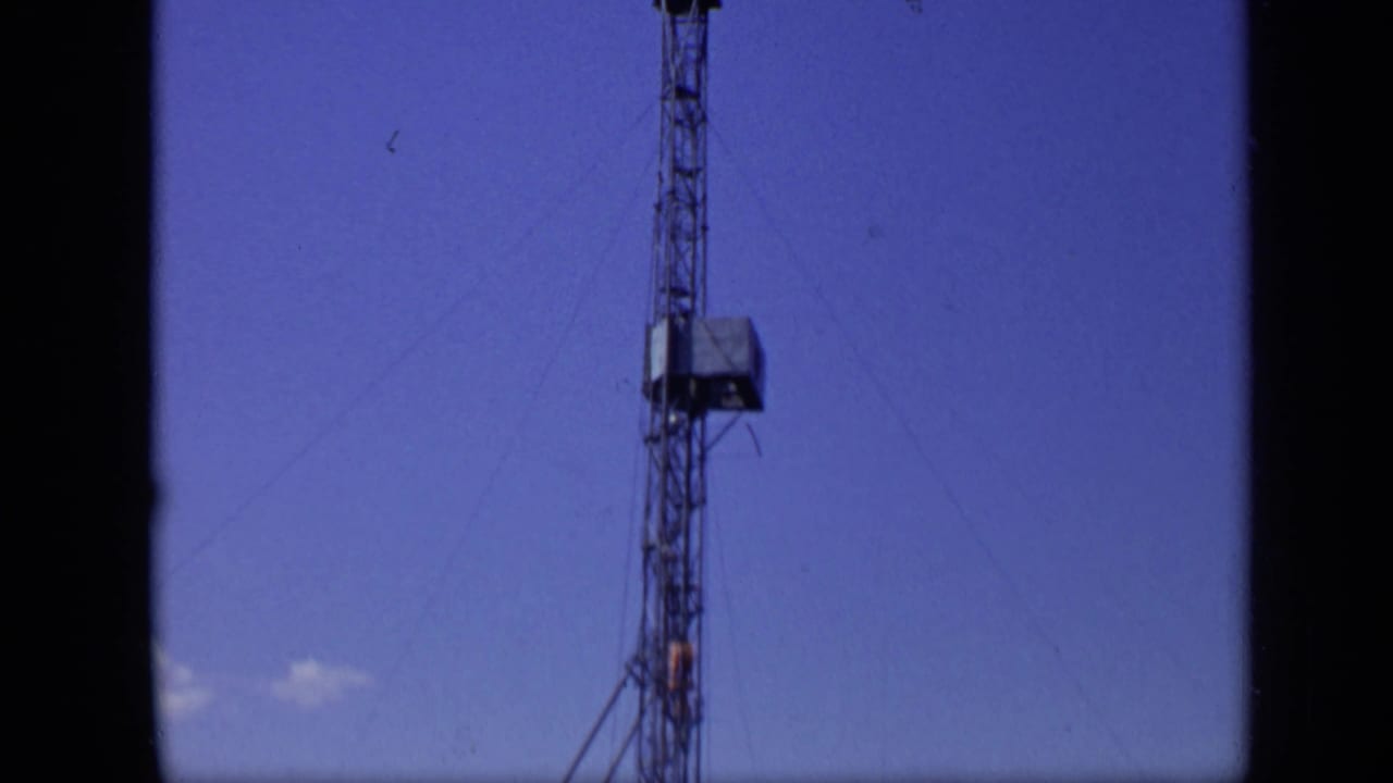 A tall tower stands against clear sky in the supplied 1971 Moscow river footage, with wires extending from the structure.