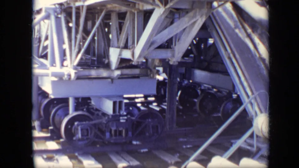 Close 8mm view of large wheels, metal framework and structural supports at the Moscow industrial site.